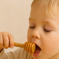 子供向けマヌカハニー – スプーン一杯のマヌカハニーを食べる子供