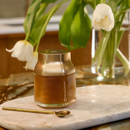Manuka Health MGO 1000+ Reserve jar on a counter with a metal spoon